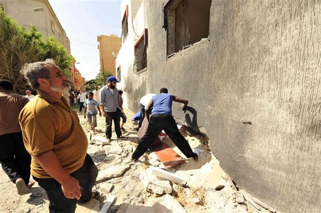 People gather to look at the damage caused by a bomb explosion at a police station in Benghazi August 2, 2013. REUTERS/Esam Omran Al-Fetori People gather to look at the damage caused by a bomb explosion at a police station in Benghazi August 2, 2013. REUTERS/Esam Omran Al-Fetori
