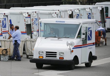 U.S. postal workers load their trucks with mail for delivery from their postal station in Carlsbad, California February 6, 2013. REUTERS/Mik U.S. postal workers load their trucks with mail for delivery from their postal station in Carlsbad, California February 6, 2013. REUTERS/Mik