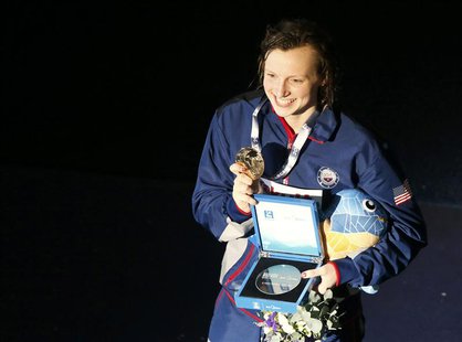 Katie Ledecky of the U.S. poses with her gold medal after setting a new world record at the women's 800m freestyle victory ceremony during t Katie Ledecky of the U.S. poses with her gold medal after setting a new world record at the women's 800m freestyle victory ceremony during t