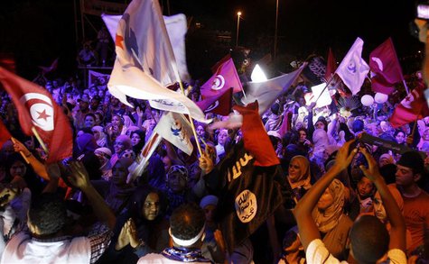 Supporters of the Islamist Ennahda movement wave flags as they chant slogans during a demonstration in support of the Ennahda government and Supporters of the Islamist Ennahda movement wave flags as they chant slogans during a demonstration in support of the Ennahda government and