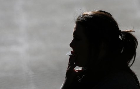 A woman is silhouetted as she smokes a cigarette in central Sydney August 1, 2013. REUTERS/Daniel Munoz A woman is silhouetted as she smokes a cigarette in central Sydney August 1, 2013. REUTERS/Daniel Munoz