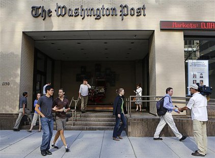 A television cameraman takes up a position as people walk by the entrance of the Washington Post headquarters in Washington, August 5, 2013. A television cameraman takes up a position as people walk by the entrance of the Washington Post headquarters in Washington, August 5, 2013.