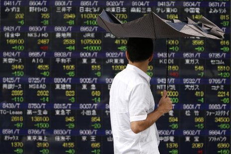 A pedestrian holding an umbrella walks past a stock quotation board displaying various stock prices outside a brokerage in Tokyo July 29, 20 A pedestrian holding an umbrella walks past a stock quotation board displaying various stock prices outside a brokerage in Tokyo July 29, 20
