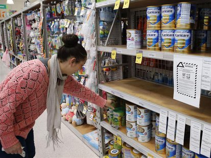 A woman browses for milk powder at a stand with a food recall notice from Nutricia in a supermarket in Huntly, Waikato Region in New Zealand A woman browses for milk powder at a stand with a food recall notice from Nutricia in a supermarket in Huntly, Waikato Region in New Zealand