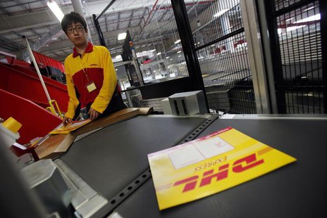 An employee stands at his workstation during a operational test of the new DHL North Asia Hub in Shanghai July 12, 2012. REUTERS/Carlos Barr An employee stands at his workstation during a operational test of the new DHL North Asia Hub in Shanghai July 12, 2012. REUTERS/Carlos Barr