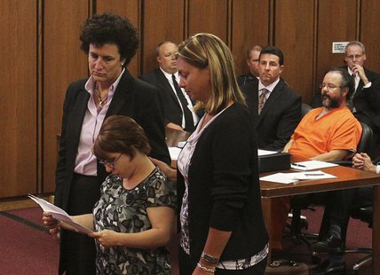 Michelle Knight (2nd from left) reads statements while supported by her attorney (L) and friend as her accused assailant Ariel Castro (R) si Michelle Knight (2nd from left) reads statements while supported by her attorney (L) and friend as her accused assailant Ariel Castro (R) si