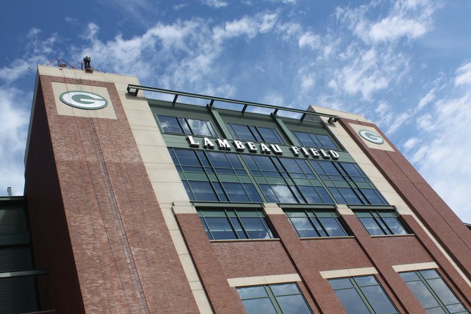 A participant sits on the ledge above the "G" ready to rappel