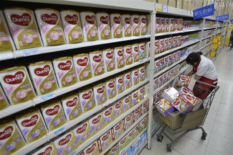 A sales assistant takes down Dumex milk powder products from shelves, which were included in a recall program by Fonterra, at a supermarket A sales assistant takes down Dumex milk powder products from shelves, which were included in a recall program by Fonterra, at a supermarket