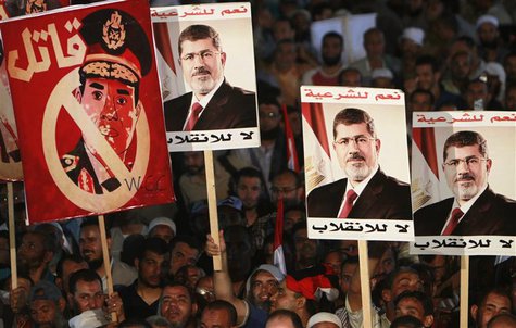 Supporters of deposed Egyptian President Mohamed Mursi hold up posters, including Egypt's army chief General Abdel Fattah al-Sisi (L) that r Supporters of deposed Egyptian President Mohamed Mursi hold up posters, including Egypt's army chief General Abdel Fattah al-Sisi (L) that r