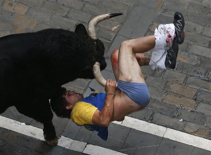 A runner gets gored by a bull on Estafeta street during the sixth running of the bulls of the San Fermin festival in Pamplona, Spain, in thi A runner gets gored by a bull on Estafeta street during the sixth running of the bulls of the San Fermin festival in Pamplona, Spain, in thi
