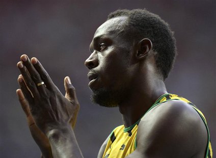 Usain Bolt of Jamaica applauds after winning his men's 100 metres heats during the IAAF World Athletics Championships at the Luzhniki stadiu Usain Bolt of Jamaica applauds after winning his men's 100 metres heats during the IAAF World Athletics Championships at the Luzhniki stadiu