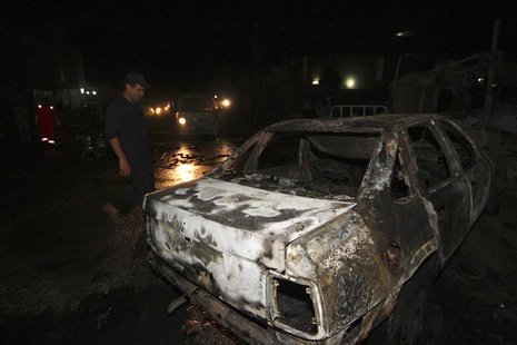 An Iraqi security force personnel inspects the site of a car bomb attack in Kerbala, 110 km (68 miles) south of Baghdad, August 10, 2013. RE An Iraqi security force personnel inspects the site of a car bomb attack in Kerbala, 110 km (68 miles) south of Baghdad, August 10, 2013. RE