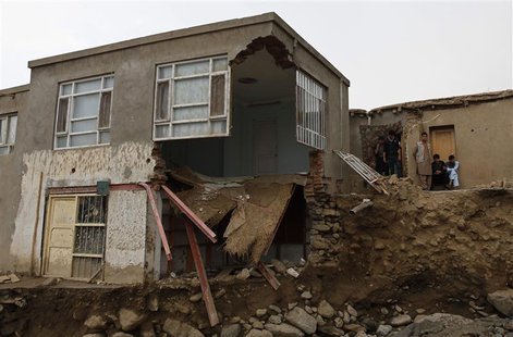 Afghans stand near a destroyed house after floods in the Shakar Dara district of Kabul August 11, 2013. REUTERS/Mohammad Ismail Afghans stand near a destroyed house after floods in the Shakar Dara district of Kabul August 11, 2013. REUTERS/Mohammad Ismail
