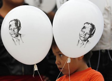 A child holds up balloons with images of former South African President Nelson Mandela as he participates in a celebration to mark Mandela's A child holds up balloons with images of former South African President Nelson Mandela as he participates in a celebration to mark Mandela's