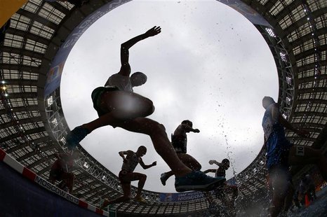 Competitors jump a water obstacle in the men's 3000 metres steeplechase heat during the IAAF World Athletics Championships at the Luzhniki S Competitors jump a water obstacle in the men's 3000 metres steeplechase heat during the IAAF World Athletics Championships at the Luzhniki S