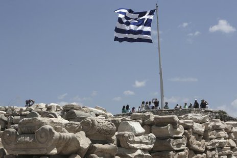 A Greek flug flutters at the top of the Acroplis hill in Athens July 2, 2013. REUTERS/John Kolesidis A Greek flug flutters at the top of the Acroplis hill in Athens July 2, 2013. REUTERS/John Kolesidis