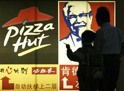 People stand in front of a poster of KFC and Pizza Hut in Guangzhou, capital of south China's Guangdong province April 2, 2007. REUTERS/Joe People stand in front of a poster of KFC and Pizza Hut in Guangzhou, capital of south China's Guangdong province April 2, 2007. REUTERS/Joe