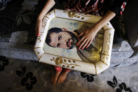 Verde holds a framed portrait of her relative, Palestinian prisoner Jamil Nabi Annatsheh, ahead of his release from an Israeli prison, in th Verde holds a framed portrait of her relative, Palestinian prisoner Jamil Nabi Annatsheh, ahead of his release from an Israeli prison, in th