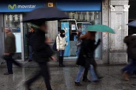 A man talks on his cell phone outside a Movistar store as people walk past in Madrid February 28, 2013. REUTERS/Susana Vera A man talks on his cell phone outside a Movistar store as people walk past in Madrid February 28, 2013. REUTERS/Susana Vera