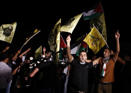 Palestinians wave flags and shout as they await the release of prisoners outside the Israeli prison of Ofer, near the West Bank city of Rama Palestinians wave flags and shout as they await the release of prisoners outside the Israeli prison of Ofer, near the West Bank city of Rama