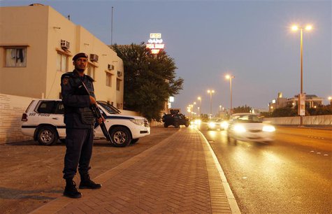 A riot police officer stands on the side of a highway as patrol vehicles, including an armoured personnel carrier, are seen behind him durin A riot police officer stands on the side of a highway as patrol vehicles, including an armoured personnel carrier, are seen behind him durin