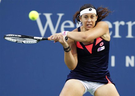 Marion Bartoli of France hits a return to Simona Halep of Romania during their women's singles match at the Cincinnati Open tennis tournamen Marion Bartoli of France hits a return to Simona Halep of Romania during their women's singles match at the Cincinnati Open tennis tournamen