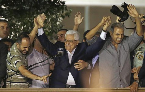 Palestinian President Mahmoud Abbas (C) holds hands with Palestinian prisoners who were released from Israeli prisons during celebrations in Palestinian President Mahmoud Abbas (C) holds hands with Palestinian prisoners who were released from Israeli prisons during celebrations in