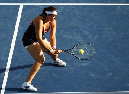 Marion Bartoli of France hits a return to Simona Halep of Romania during their women's singles match at the Cincinnati Open tennis tournamen Marion Bartoli of France hits a return to Simona Halep of Romania during their women's singles match at the Cincinnati Open tennis tournamen