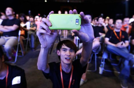 A user of Xiaomi uses his mobile phone to take a photo at a launch ceremony of Xiaomi Phone 2 in Beijing August 16, 2012. REUTERS/Jason Lee A user of Xiaomi uses his mobile phone to take a photo at a launch ceremony of Xiaomi Phone 2 in Beijing August 16, 2012. REUTERS/Jason Lee