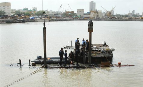Navy divers standing on the INS Sindhurakshak submarine prepare to dive into the waters of the Arabian Sea, during a rescue operation in Mum Navy divers standing on the INS Sindhurakshak submarine prepare to dive into the waters of the Arabian Sea, during a rescue operation in Mum