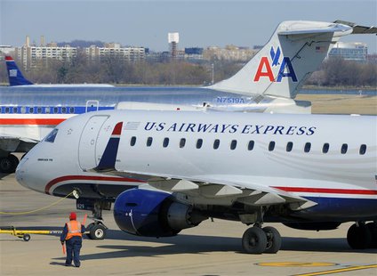 A US Airways Express plane (foreground) departs from a gate past an American Airlines plane (background) at the Ronald Reagan Washington Nat A US Airways Express plane (foreground) departs from a gate past an American Airlines plane (background) at the Ronald Reagan Washington Nat