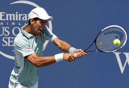 Novak Djokovic of Serbia hits a return ball to John Isner of the U.S. in their quarterfinal round match at the Men's Cincinnati Open tennis Novak Djokovic of Serbia hits a return ball to John Isner of the U.S. in their quarterfinal round match at the Men's Cincinnati Open tennis