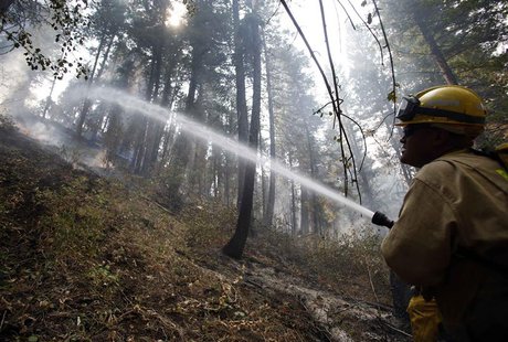 Firefighter Henry Munoz sprays down a hotspot at the Elk Complex wildfire outside Boise, Idaho August 15, 2013. Together with the Elk, Pony, Firefighter Henry Munoz sprays down a hotspot at the Elk Complex wildfire outside Boise, Idaho August 15, 2013. Together with the Elk, Pony,