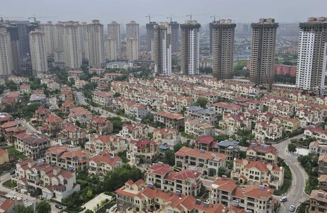 A block of villa residences is seen in front of new residential buildings under construction in Shenyang, Liaoning province July 18, 2013. R A block of villa residences is seen in front of new residential buildings under construction in Shenyang, Liaoning province July 18, 2013. R