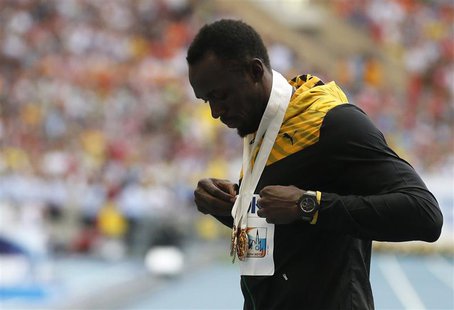 Usain Bolt of Jamaica poses with three gold medals after the victory ceremony for the men's 4x100 metres relay at the IAAF World Athletics C Usain Bolt of Jamaica poses with three gold medals after the victory ceremony for the men's 4x100 metres relay at the IAAF World Athletics C
