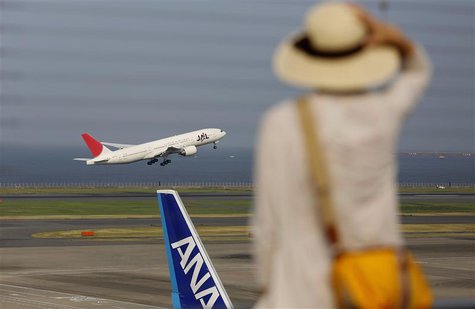 A woman watches a Japan Airlines (JAL) aeroplane (C) taking off behind an All Nippon Airways' (ANA) aeroplane at Haneda airport in Tokyo Aug A woman watches a Japan Airlines (JAL) aeroplane (C) taking off behind an All Nippon Airways' (ANA) aeroplane at Haneda airport in Tokyo Aug