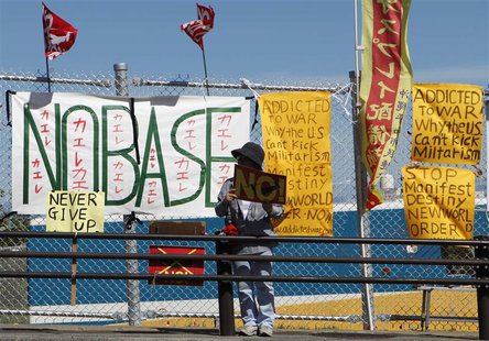 A man, protesting against the deployment of the Osprey military aircraft in the city and demanding close of the base, stands in front of the A man, protesting against the deployment of the Osprey military aircraft in the city and demanding close of the base, stands in front of the
