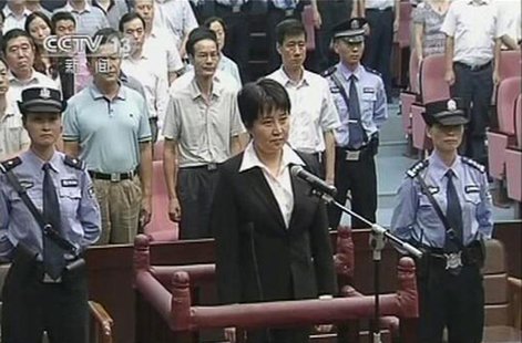Gu Kailai (C), wife of ousted Chinese Communist Party Politburo member Bo Xilai, stands at the defendant's dock during a trial in the court Gu Kailai (C), wife of ousted Chinese Communist Party Politburo member Bo Xilai, stands at the defendant's dock during a trial in the court
