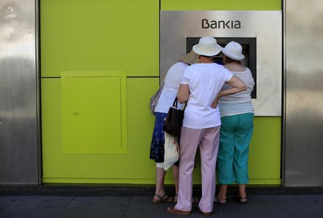 People use an ATM machine at a branch of Spain's nationalized lender Bankia in the Andalusian capital of Seville, southern Spain, June 24, 2 People use an ATM machine at a branch of Spain's nationalized lender Bankia in the Andalusian capital of Seville, southern Spain, June 24, 2