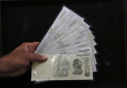 A jeweller poses with silver plates in the form of Indian rupee notes inside a showroom in New Delhi August 19, 2013. REUTERS/Mansi Thapliya A jeweller poses with silver plates in the form of Indian rupee notes inside a showroom in New Delhi August 19, 2013. REUTERS/Mansi Thapliya
