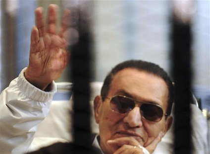 Former Egyptian President Hosni Mubarak waves to his supporters inside a cage in a courtroom at the police academy in Cairo, in this file pi Former Egyptian President Hosni Mubarak waves to his supporters inside a cage in a courtroom at the police academy in Cairo, in this file pi