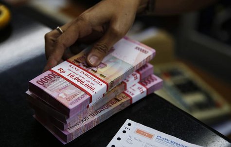 A money changer holds stacks of Indonesian rupiah notes in Jakarta August 20, 2013. REUTERS/Beawiharta A money changer holds stacks of Indonesian rupiah notes in Jakarta August 20, 2013. REUTERS/Beawiharta