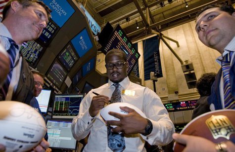 NFL draft prospect Von Miller signs a football for traders on the New York Stock Exchange floor before he rings the closing bell in New York NFL draft prospect Von Miller signs a football for traders on the New York Stock Exchange floor before he rings the closing bell in New York