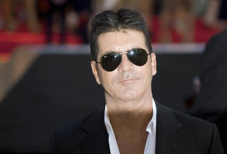 Television mogul Simon Cowell poses for photographers as he arrives for the film "One Direction: This is Us", in London August 20, 2013. REU Television mogul Simon Cowell poses for photographers as he arrives for the film "One Direction: This is Us", in London August 20, 2013. REU