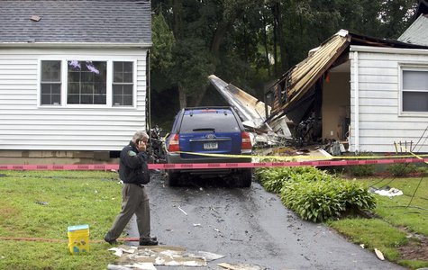 The remains of a plane is seen next to a damaged home after it crashed in East Haven, August 9, 2013. REUTERS/Michelle McLoughlin The remains of a plane is seen next to a damaged home after it crashed in East Haven, August 9, 2013. REUTERS/Michelle McLoughlin