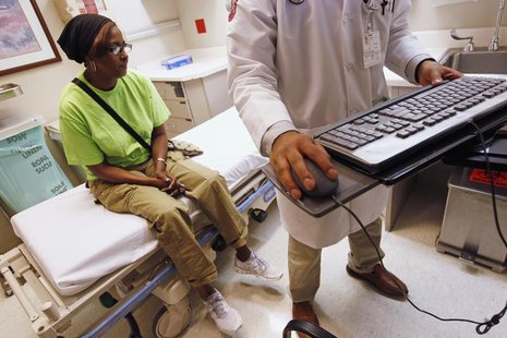 Patient Sharon Dawson Coates (L) waits as Dr. Nikhil Narang enters data into her chart after examining her knee at University of Chicago Med Patient Sharon Dawson Coates (L) waits as Dr. Nikhil Narang enters data into her chart after examining her knee at University of Chicago Med