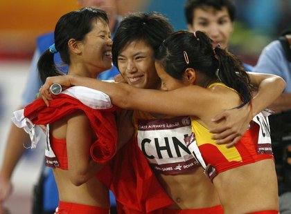 China's (L-R) Han Ling, Wang Jing and Qin Wangping celebrate after winning the women's 4x100m relay race final during the 15th Asian Games i China's (L-R) Han Ling, Wang Jing and Qin Wangping celebrate after winning the women's 4x100m relay race final during the 15th Asian Games i