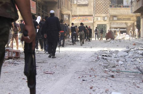 Free Syrian Army fighters carry their weapons as they walk towards the frontline in the refugee camp of Yarmouk, near Damascus August 19, 20 Free Syrian Army fighters carry their weapons as they walk towards the frontline in the refugee camp of Yarmouk, near Damascus August 19, 20