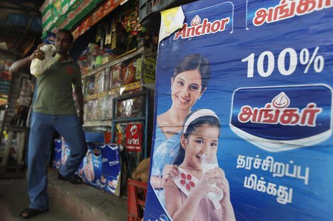 An advertisement for Fonterra's Anchor powder brand is seen at a shop as a customer walks by in Colombo August 15, 2013, a day before the an An advertisement for Fonterra's Anchor powder brand is seen at a shop as a customer walks by in Colombo August 15, 2013, a day before the an