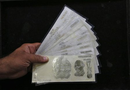 A jeweller poses with silver plates in the form of Indian rupee notes inside a showroom in New Delhi August 19, 2013. REUTERS/Mansi Thapliya A jeweller poses with silver plates in the form of Indian rupee notes inside a showroom in New Delhi August 19, 2013. REUTERS/Mansi Thapliya